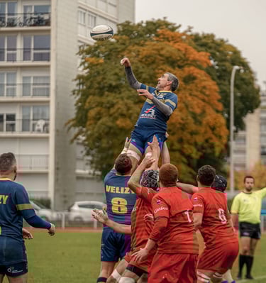 Joueur de rugby porté par ses coéquipiers pour récupérer une balle en touche