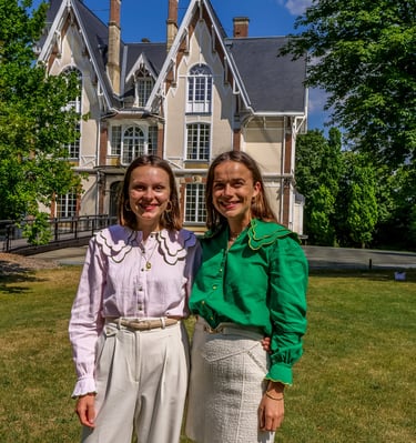 Deux personnes qui posent devant un chateau en souriant