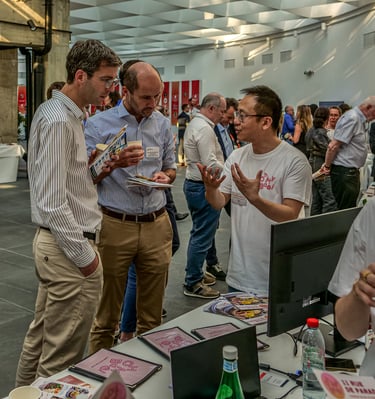 Trois hommes devant un stand qui discutent d'une entreprise qui frabrique des Baos