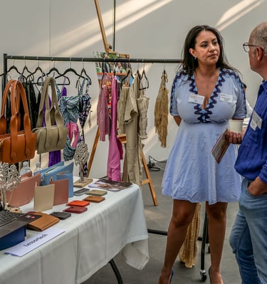 Un homme et une femme qui discute devant des articles de maroquinerie un stand qui vend