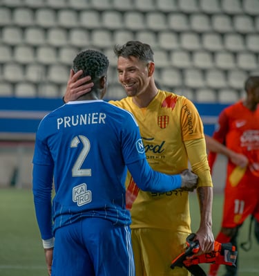 Gardien de Martigues et défenseur de Versailles qui font une accolade après le match