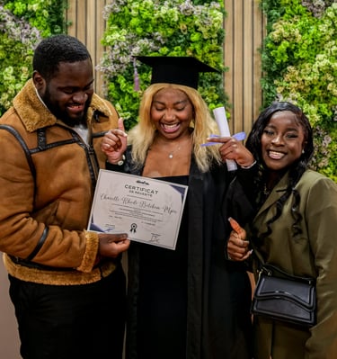 Une étudiante qui pose avec sa famille et son diplôme dans les mains