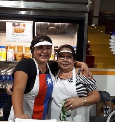 two women standing in front of a counter top