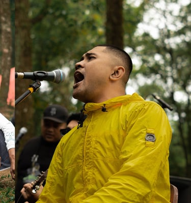a man in a yellow jacket singing into a microphone