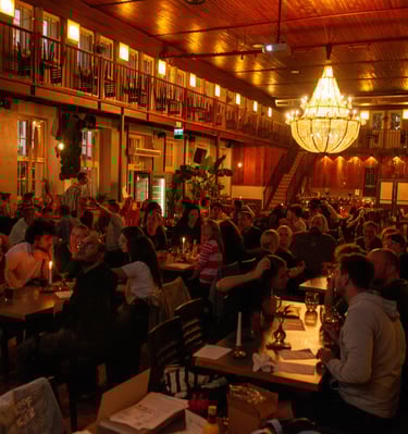 Menschen sitzen in Gruppen beim Quiz in Berlin