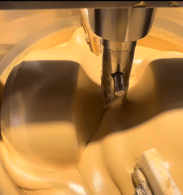 white chocolate being prepared in a chocolate grinding machine
