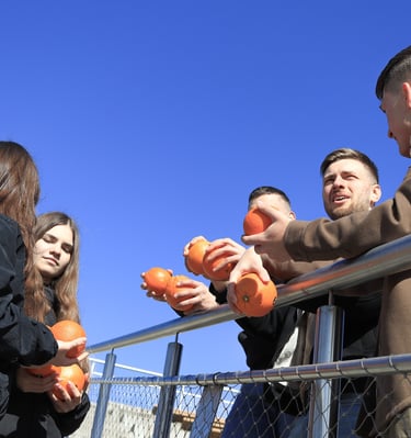 jauni zmones lauke sneka ir rankose laiko apelsinus