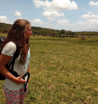 Tourist standing on the savannah landscape in Tarangire National Park observing wildlife during a Tanzania safari tour.