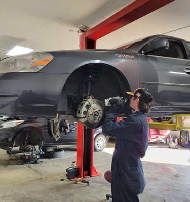 Mechanic Hard at Work Fixing Brakes and Suspension