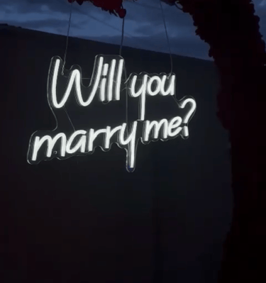 zoom sur un néon "Will you marre me?" lors d'une demande en mariage