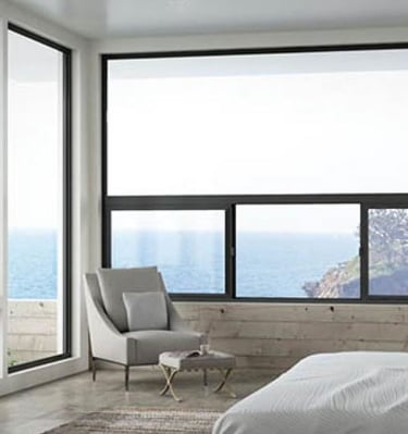 a bedroom with a large window and a chair