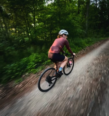 a woman riding a bike on a dirt road