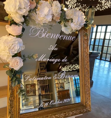 a sign board with flowers and a mirror