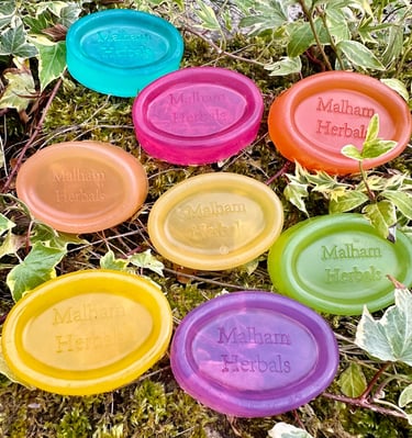 colourful unwrapped essential oil soaps on a natural background.