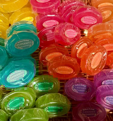 Colourful wrapped essential oil soaps in a basket.