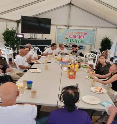 a group of people sitting around a table - outdoor gathering