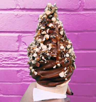 une glace a l'italienne trempée dans du chocolat fondant avec des éclats de cacahuètes 