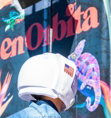 Portrait of a kid wearing a space helmet at a festival called 'En  Órbita'