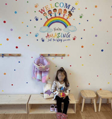 Willkommensbereich für Kinder mit Regenbogen-Dekoration – positive Atmosphäre in der Spielgruppe Spr