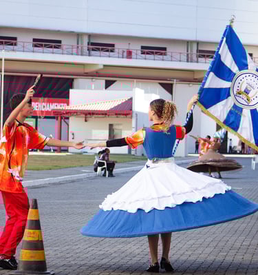 uma porta bandeira e um mestre sala ensaiando, a porta bandeira com o pavilhao da Filhos da Santa