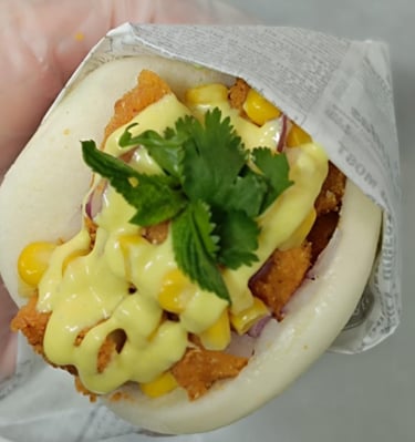 a person holding a sandwich with cheese and cheese
