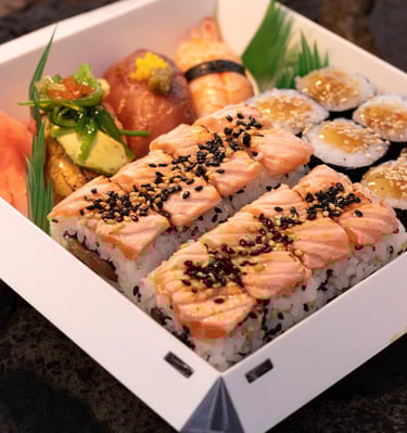 a box of sushi with salmon and vegetables