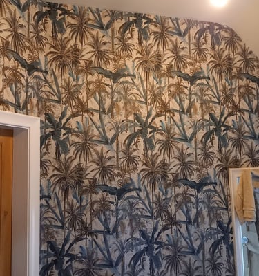 a bathroom with a wallpapered wall showing palm trees