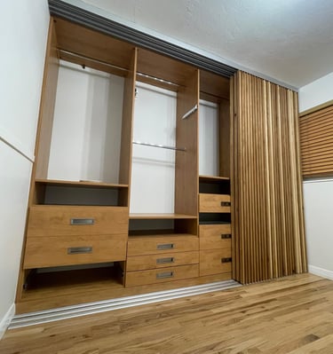 Walk-in closet with custom cabinetry by Portugal Woodworks in Utah, featuring drawers and shelves.