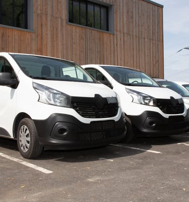 a group of four vans parked in a parking lot