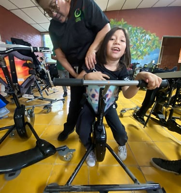 Un enfant handicapé avec l'appareillage et 1 femme du centre de réhabilitation