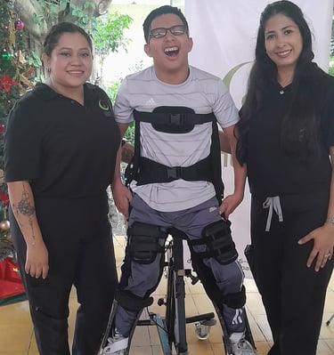 Un enfant handicapé avec l'appareillage et 2 femmes du centre de réhabilitation