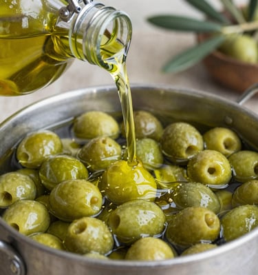 Close-up of a drop of golden olive oil falling from a bottle spout