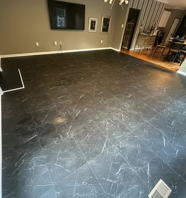 a living room with a large black vinyl tile floor