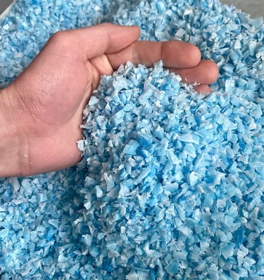 Gros plan sur du broyât de plastique PEHD recyclé bleu