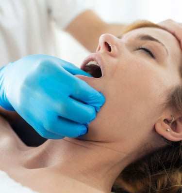 TMJ massage therapy on a woman to relieve jaw pain.