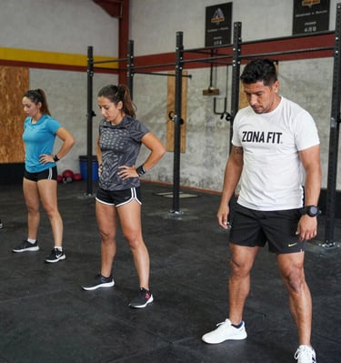 Athletes pushing through a CrossFit workout using gym apparatus with determination.