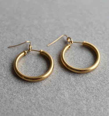 Elegant silver earrings with intricate filigree details displayed on a marble surface.