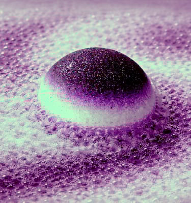 Extra large bath bomb with deep purple center surrounded by foamy lavender fizz.