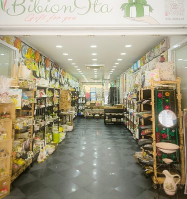Inside a BibionIta boutique gift shop featuring shelves of colorful ceramics, home decor, and textiles.