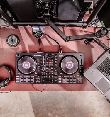 Top-down view of a professional DJ controller, laptop, and headphones on a mobile Dj Buggy