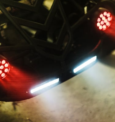 Custom Dj off-road vehicle with glowing red LED tail lights and white safety light bars.