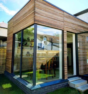 Modern garden extension with horizontal timber cladding and large glass corner windows.