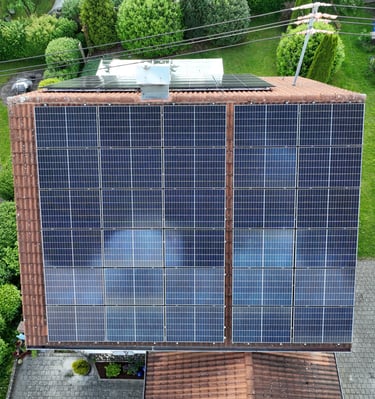 Aerial view of a residential rooftop with solar panels installed for renewable energy.