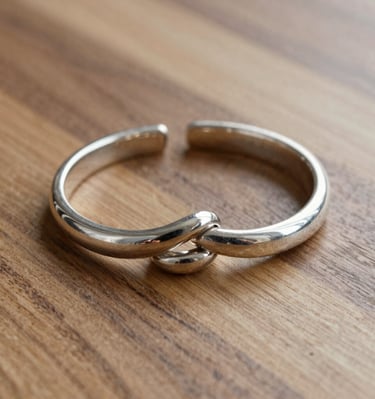 Elegant silver bracelet with subtle engravings, photographed on a black background.