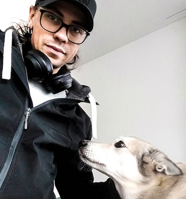 lächelnder Mann mit Brille und schwarzer Baseballkappe mit grauem Hund