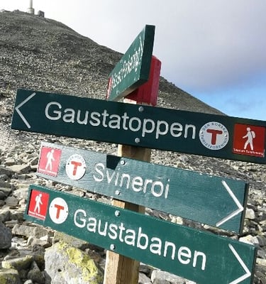 a directional sign with a mountain in the background-wikiloc site