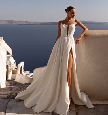 a woman in a white dress standing on a balcony