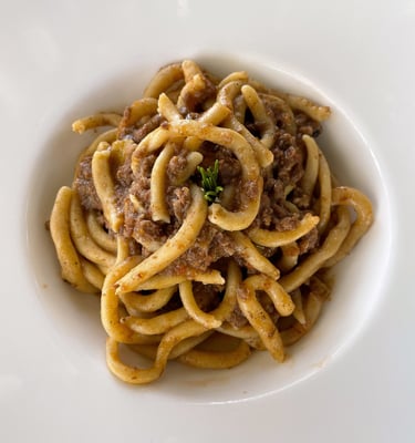 Plate of pici toscani with white ragu 