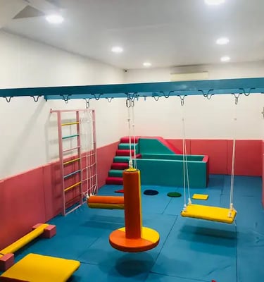 sebuah ruang sensori intergasi anak dengan ayunan perosotan dan kolam bola