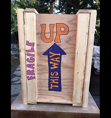 Shipping crate for Talbotics sculpture with image of arrow pointing up drawn on it.